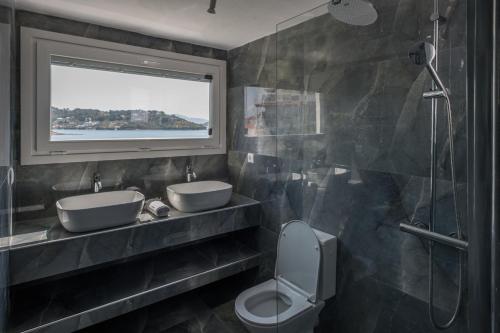 a bathroom with two sinks and a shower at Para Thin Alos Skiathos in Skiathos Town