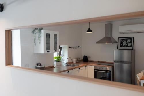 a kitchen with white cabinets and a stainless steel refrigerator at Relax Home Funtana in Funtana