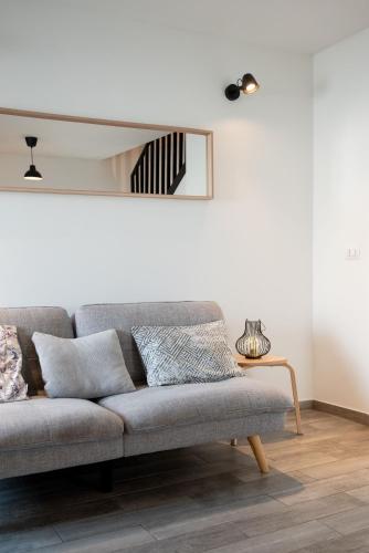 a living room with a couch and a mirror at Relax Home Funtana in Funtana