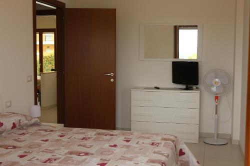 a bedroom with a bed and a dresser with a fan at La Dimora del Colle in San Vito Chietino