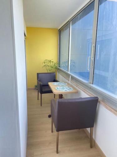 une chambre avec deux chaises, une table et une fenêtre dans l'établissement Studio avec loggia, classé 2 étoiles, situé sur le port, à Courseulles-sur-Mer