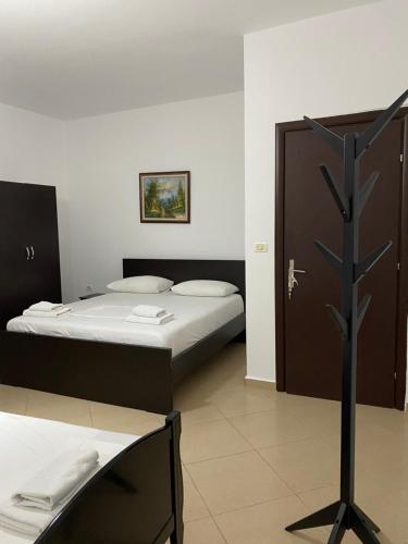 a bedroom with two beds and a tree in it at Vila Enea in Ksamil