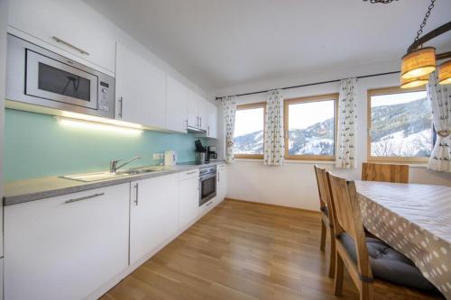 a kitchen with white cabinets and a table with chairs at Mountainresort Top 6 in Dienten am Hochkönig