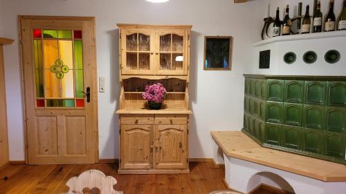 a room with a wooden cabinet with a vase of flowers at Ferienhaus Lodenwalcher in Schwarzschachen