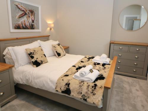 1 dormitorio con 1 cama con toallas y espejo en Hunter's Lodge, en Buxton