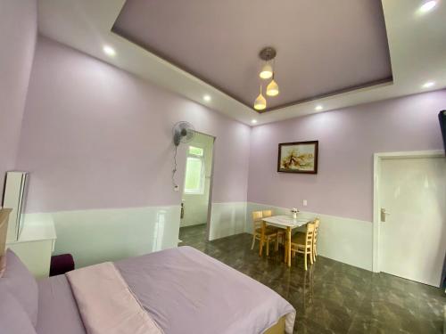 a bedroom with a bed and a table with chairs at NHÀ MÁ TOÁN - Bảo Lộc in Ấp Tân Hà