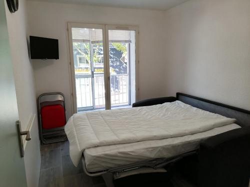 un lit dans une chambre avec une fenêtre dans l'établissement Logement bord de y, à Les Sables-dʼOlonne