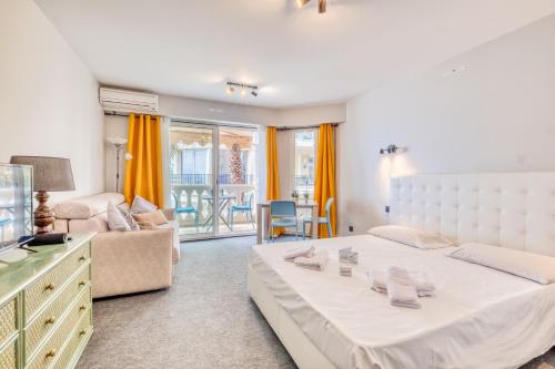 une chambre avec un grand lit et un salon dans l'établissement Victoria Beach, à Menton