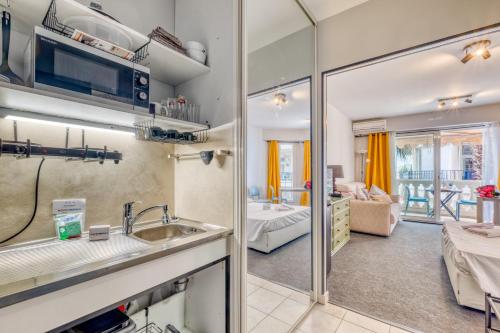 une cuisine avec un évier et un salon dans l'établissement Victoria Beach, à Menton