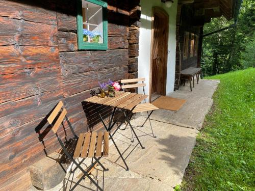 a wooden table and chairs outside of a cabin at Ferienhaus Lodenwalcher in Schwarzschachen