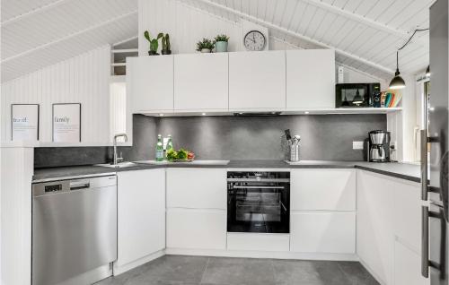 a white kitchen with white cabinets and an oven at 3 Bedroom Cozy Home In Jerup in Jerup