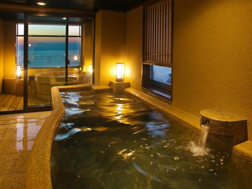 a bathtub in a hotel room with a water fountain at Asahiro in Minabe