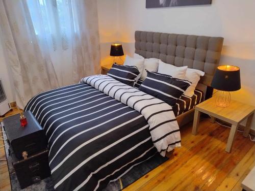 a bedroom with a large bed with blue and white stripes at Résidence La Tonnelle in Antananarivo