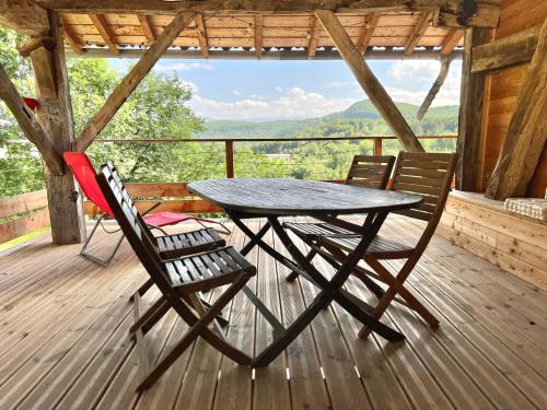 - une table et des chaises sur une terrasse avec vue dans l'établissement Brasserie des Paloufettes - Gîte classé 3 étoiles, à Le Mas-dʼAzil