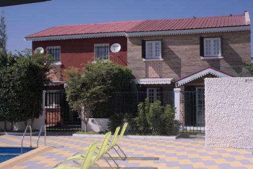 a house with a pool and chairs in front of it at Résidence La Tonnelle in Antananarivo