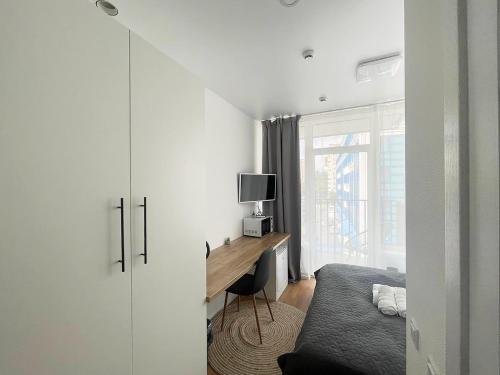 een slaapkamer met een bureau, een bed en een raam bij Люкс апартаменти в затишному ЖК бізнес класу in Kiev