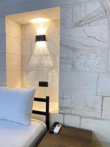 a bedroom with a bed with a remote control on a table at Mezopotamya Ruya Konak in Urfa