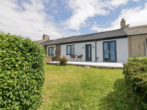a house with a hedge in front of it at Victroneen Cottage in Whitehaven