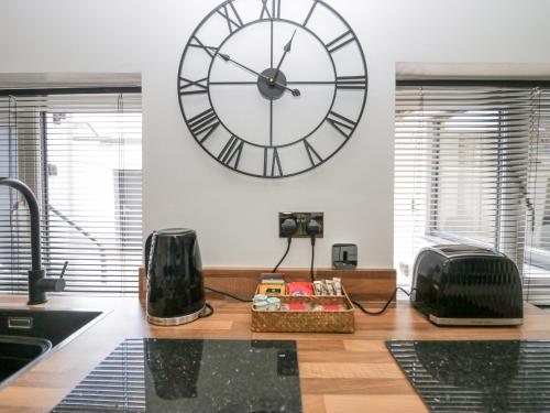 a large clock on the wall in a kitchen at Victroneen Cottage in Whitehaven