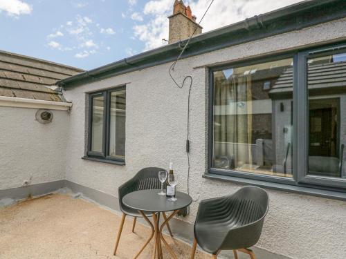 a patio with two chairs and a table in front of a house at Victroneen Cottage in Whitehaven