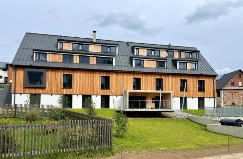 a large wooden house with a metal roof at Apartmány Šestka in Staré Město