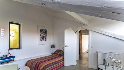 une chambre avec un lit dans une pièce aux murs blancs dans l'établissement Loft 92 - Avec belle terrasse proche de Paris, à Ville-dʼAvray