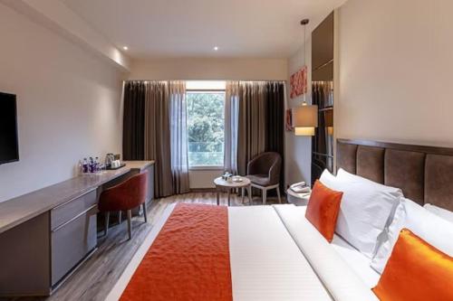 a hotel room with a bed and a desk at Hotel Saket 27 in New Delhi
