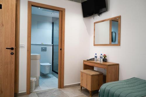 una camera da letto con un letto e un bagno con uno specchio di Hôtel Suisse Tunis a Tunisi