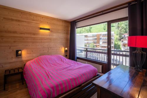 une chambre avec un lit et une grande fenêtre dans l'établissement Les 2 alpes appartement entier 6pers., à Mont-de-Lans