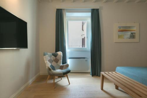 a living room with a chair and a window at Suite Greve in Chianti in Greve in Chianti