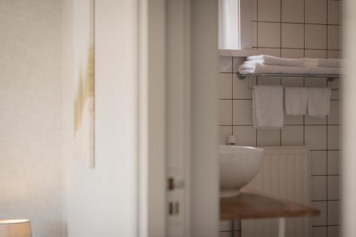 a bathroom with a sink and white towels at Hotel Groede in Groede