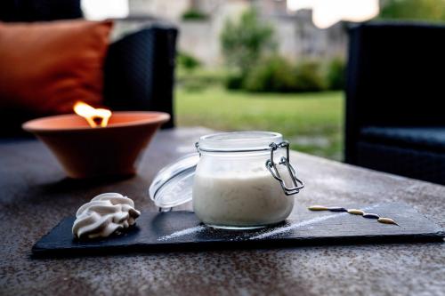 a jar of soy sauce and a candle on a table at Logis L'Auberge de Larressingle in Larressingle