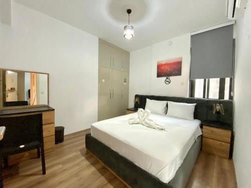 a bedroom with a large white bed and a desk at Luxurious Brand New Apartment in the City Centre in Kérynia