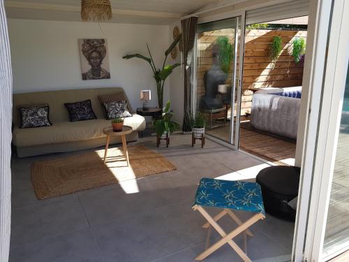 un salon avec un canapé et une table dans l'établissement Tropical Couple, à Marignane