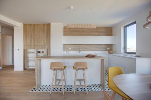- une cuisine avec deux tabourets de bar et une table dans l'établissement GuestReady - Séjour lumineux et élégant à Bordeaux, à Bordeaux