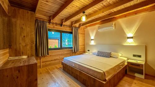 a bedroom with a bed in a wooden room at Kaş Konak Bungalows in Kaş