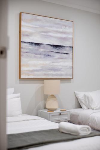 a bedroom with two beds and a painting on the wall at Farm Stay Picturesque views in Balhannah