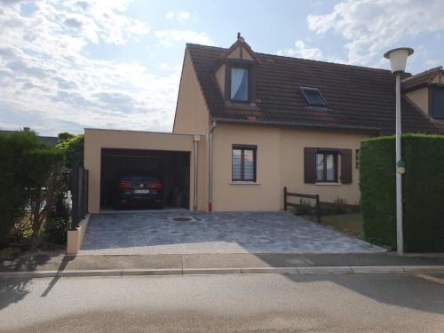 une maison avec un garage avec une voiture dans l'établissement Chez Serge et Francine, à Horbourg-Wihr