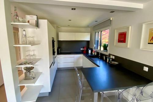 une cuisine avec des placards blancs et un comptoir bleu dans l'établissement Magnifique maison contemporaine, à Messery