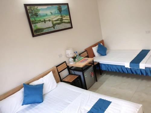a room with two beds and a table in it at Cherry homestay in Ninh Binh