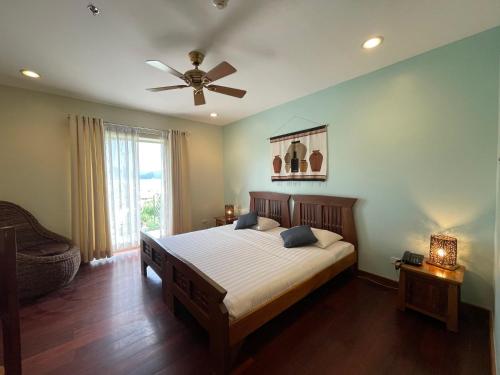 a bedroom with a bed and a ceiling fan at Corto del Mar Hotel in Coron