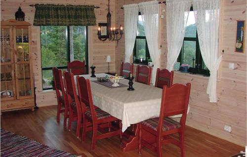a dining room with a table and chairs and windows at 5 Bedroom Awesome Home In Kvinlog in Stakkeland