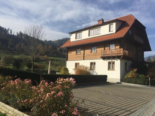 a large white house with a wooden roof at Tolles Appartement in Marktgemeinde Übelbach mit Garten in Übelbach