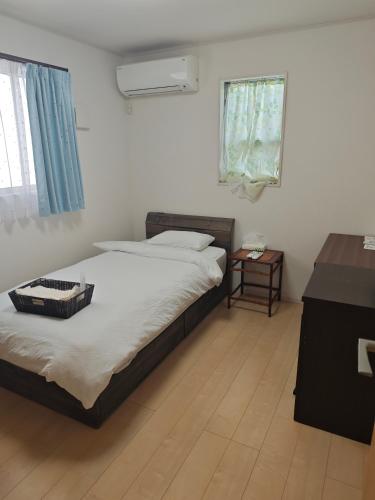 a bedroom with two twin beds and a window at 有間宿泊 in Tokoname