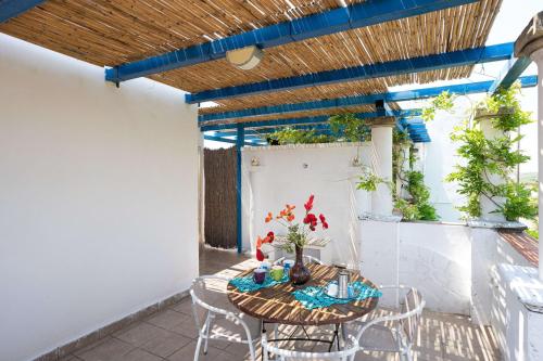a patio with a wooden table and chairs at Casa Tulipano 2 DX a soli 200 mt dal mare di Torre Colimena in Torre Colimena