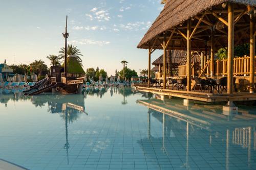 a pool of water with a building and a resort at AQI Pegasos World in Side