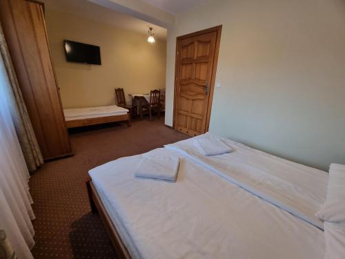 a bedroom with a bed with two towels on it at Willa pod Smrekiem in Białka Tatrzanska