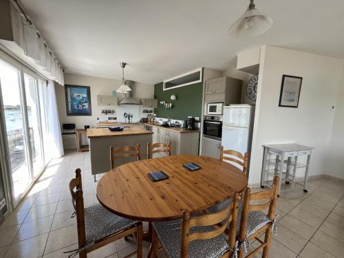 une cuisine et une salle à manger avec une table et des chaises en bois dans l'établissement La Vie, à Saint-Gilles-Croix-de-Vie