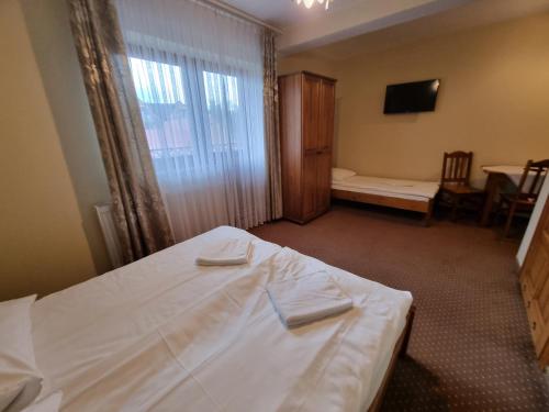 a bedroom with a bed with two towels on it at Willa pod Smrekiem in Białka Tatrzanska