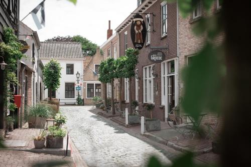 an old cobblestone street in a town with buildings at Hotel Groede in Groede